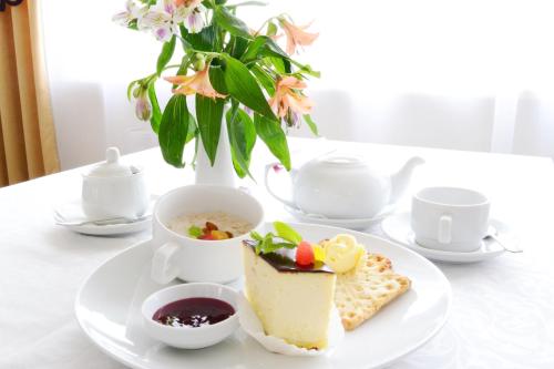 a plate with a piece of cake and a cup of tea at Argo Premium in Lviv