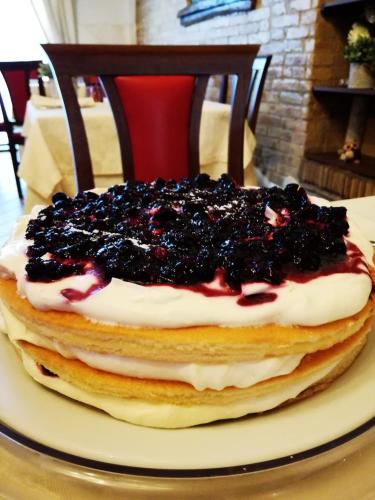 a stack of pancakes with blueberry topping on a plate at Locanda San Giorgio in Termoli