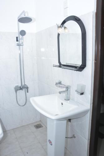 a white bathroom with a sink and a mirror at Star Nodes Villa in Galle