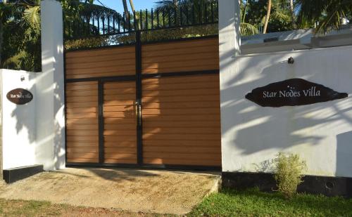 a wooden garage door with a sign that reads san nicolas villa at Star Nodes Villa in Galle
