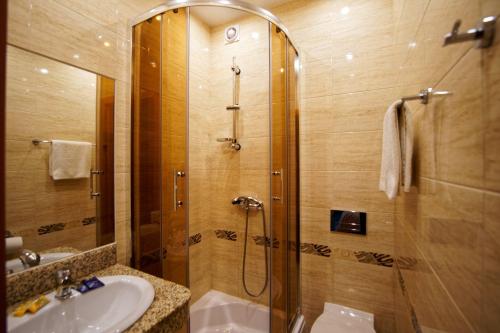 a bathroom with a shower and a sink at Antalya Pokoje i Apartamenty in Władysławowo