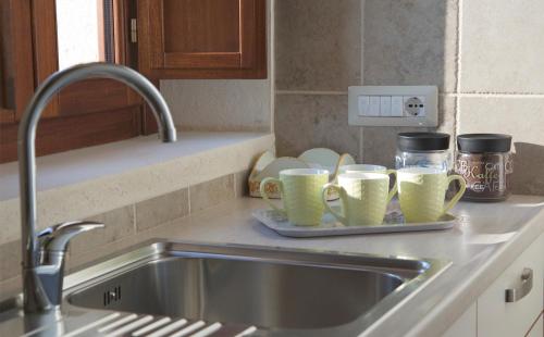 um lavatório de cozinha com três chávenas numa bandeja em Masseria Rosario em Grottaglie