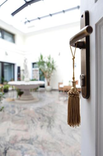 a broom hanging from a door with a living room at ApartHotel Vila Minka in Ljubljana