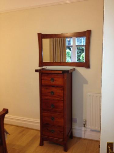 a dresser with a mirror on top of it at Dene House Guest House in Bowness-on-Windermere
