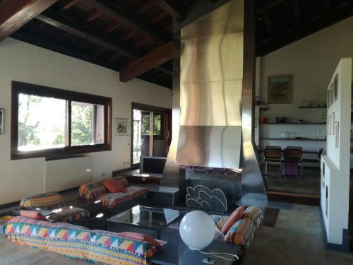 a living room with a fireplace and a couch at Oasi di Mastarone - Il vino e le Rose in Momperone