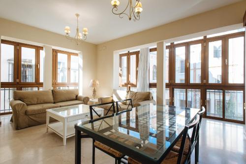 a living room with a glass table and a couch at Bright and beautiful- VTV- Conde de Torrejón 10 in Seville