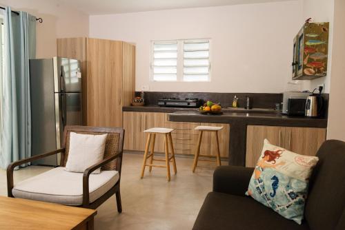 a kitchen with a couch and chairs in a room at Coconuts in Grand Baie