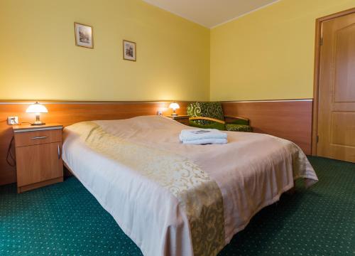 a hotel room with a large bed with two towels on it at Antalya Pokoje i Apartamenty in Władysławowo