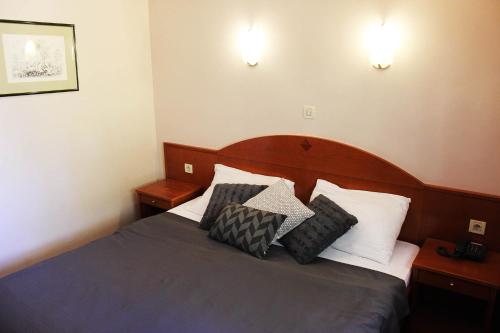 
a bed with a white comforter and pillows at Hotel Lagus in Varaždin

