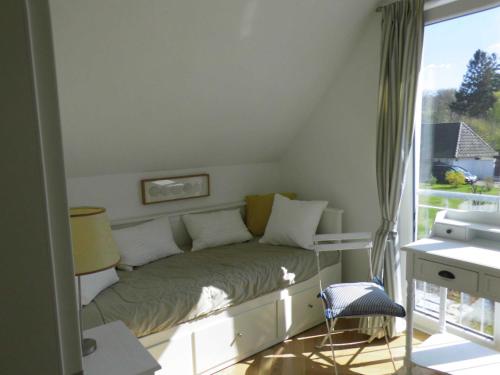 um pequeno quarto com uma cama e uma janela em Ferienwohnung Ferienhaus Hohwachter Bucht Ostsee DSL WLAN em Hohwacht