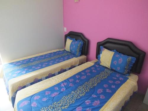 two beds sitting next to each other in a room at Vanlisut Hotel Ngamwongwan in Nonthaburi