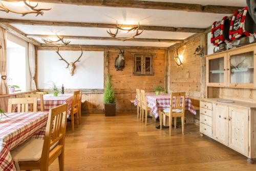 マッレス・ヴェノスタにあるMorigglhofの木製の壁の部屋にテーブルと椅子が備わるレストラン