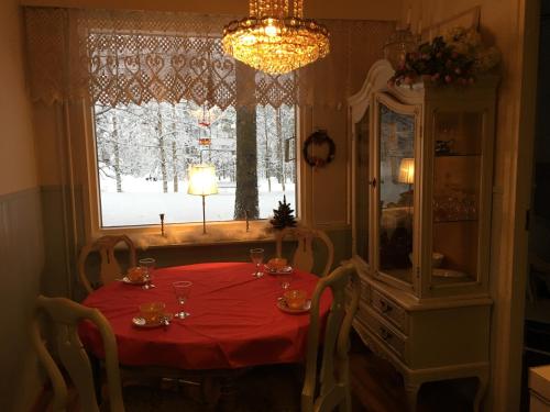 a dining room table with a red table cloth and a window at Arctic Circle Apartment in Rovaniemi