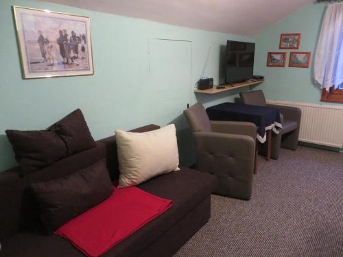 a living room with a couch and a chair at Pension Stepponat in Arnstadt