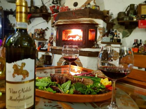 a table with a plate of food and two glasses of wine at Podgorski An in Kolešino