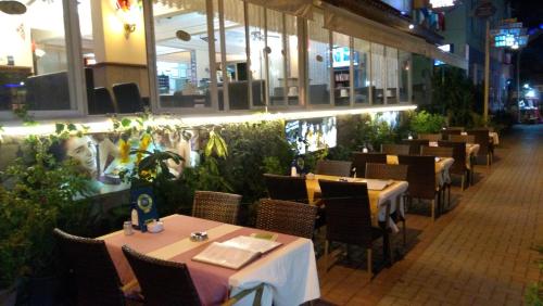 une salle à manger avec tables, chaises et plantes dans l'établissement Sunway Hotel, à Alanya