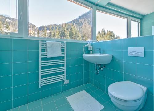Un baño azul con inodoro y lavabo. en Riverside Residence Flachau, en Flachau