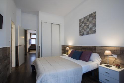 um quarto com uma grande cama branca e um espelho em Flatsforyou Turia em Valência