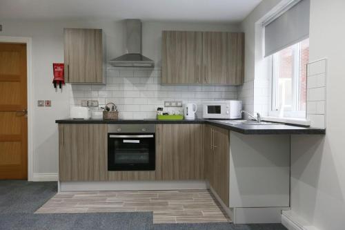 a kitchen with a sink and a microwave at Hotel 52 Stanley in Stanley