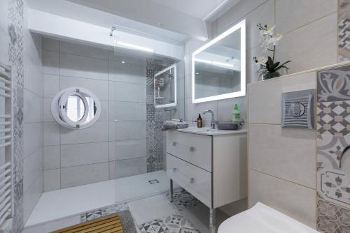 une salle de bain blanche avec un lavabo et un miroir dans l'établissement BARILLERIE - Loft Moderne, Face Mer, Vieux-Nice., à Nice
