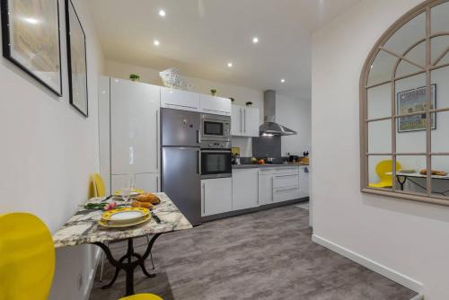 une cuisine avec une table et un réfrigérateur dans l'établissement BARILLERIE - Loft Moderne, Face Mer, Vieux-Nice., à Nice