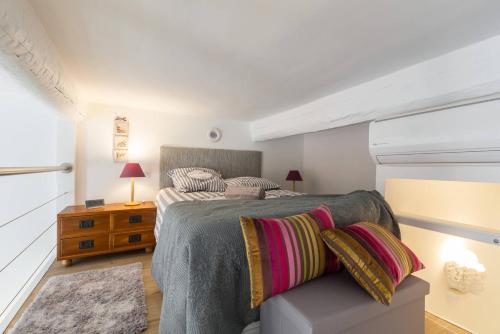 - une chambre avec un lit et une table avec une table de chevet dans l'établissement BARILLERIE - Loft Moderne, Face Mer, Vieux-Nice., à Nice