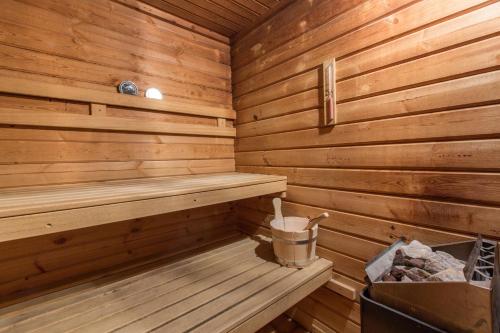 a wooden sauna with a trash can and a bucket at Hotel Les Bruyères in Morzine