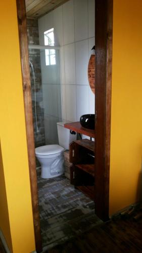 a bathroom with a toilet and a sink at Cabana Rústica Praia do Sonho in Palhoça