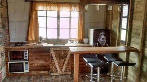cocina con mesa y taburetes en una habitación en Cabana Rústica Praia do Sonho, en Palhoça