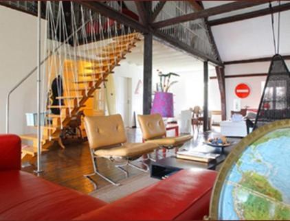 a living room with a couch and a staircase at Manoir de la Peylouse in Saint-Venant