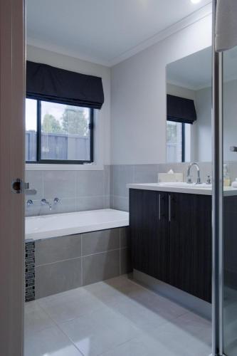 a bathroom with a bath tub and a sink at Montebello in Bright