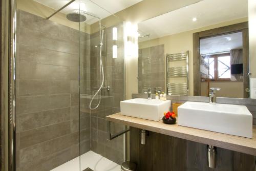 a bathroom with two sinks and a shower at Odalys Chalet Le Cabri in Val-d'Isère