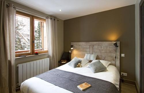 um quarto com uma cama grande e uma cabeceira em madeira em Odalys Chalet Le Cabri em Val dʼIsère