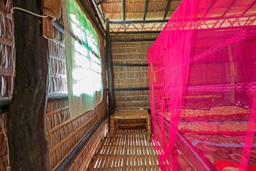 an empty room with pink curtains and a bed at Battambang Dream Bungalows in Battambang