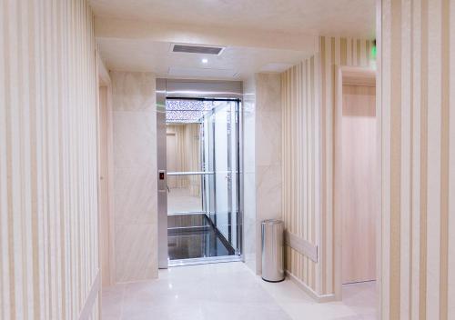 a hallway with a glass door leading to a bathroom at Hotel Capri in Plovdiv