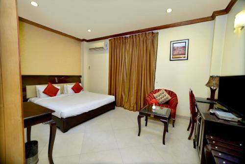 a hotel room with a bed and a desk at Pink Pearl Hotel in Jaipur