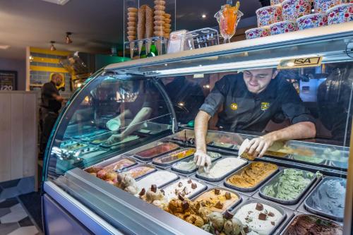 a man is preparing food in a food truck at The Raven’s Cliff Lodge by Marston's Inns in Motherwell