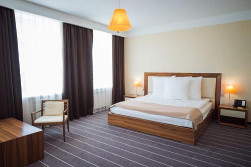 una camera d'albergo con letto e sedia di Ost West Club a Samara