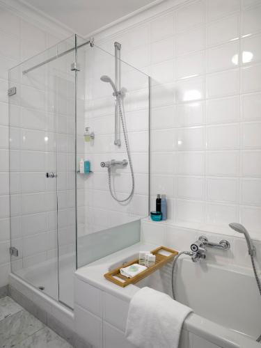 a bathroom with a shower and a tub and a sink at Landgoed De Holtweijde in Lattrop