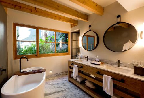 a bathroom with a tub and a large mirror at La Casa Rodavento in Valle de Bravo