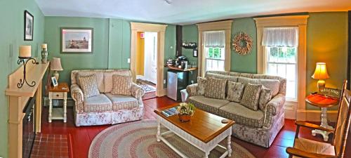 a living room with two couches and a table at Ballard House Inn in Meredith