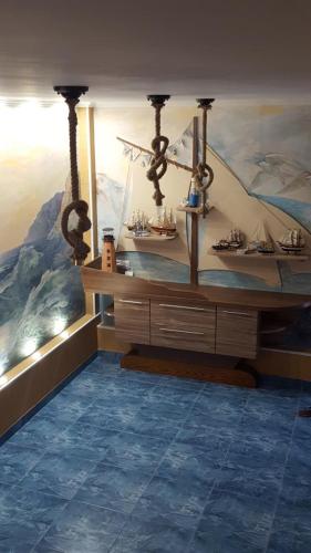 a room with a table with a boat on the wall at Панівецька Садиба in Zubrivka