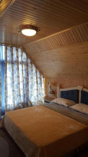a bedroom with a large bed in a wooden ceiling at Панівецька Садиба in Zubrivka