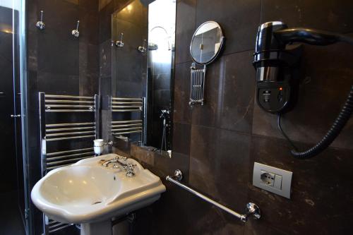 a bathroom with a sink and a phone on the wall at Gagliardi Boutique Hotel in Noto