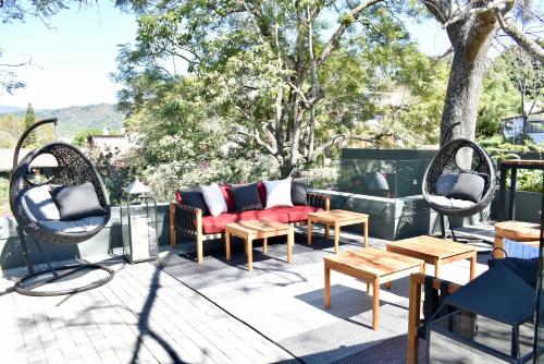 a patio with two chairs and a couch and tables at La Casa Rodavento in Valle de Bravo