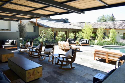 a patio with chairs and tables and a pool at La Casa Rodavento in Valle de Bravo