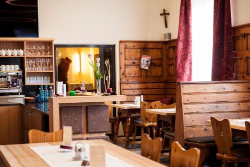 a restaurant with wooden tables and chairs and a counter at Hotel Guidassoni in Leibnitz