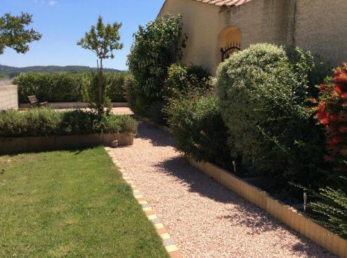 a garden with bushes and a walkway at Le Claouraous calme in Canet