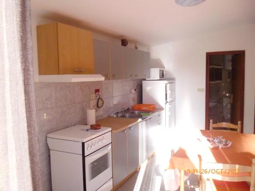 a kitchen with a white stove and a refrigerator at Apartments Lidija in Pag