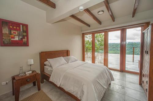 1 dormitorio con cama y ventana grande en Kapari Natural Lodge & Spa, en San Miguel de los Bancos